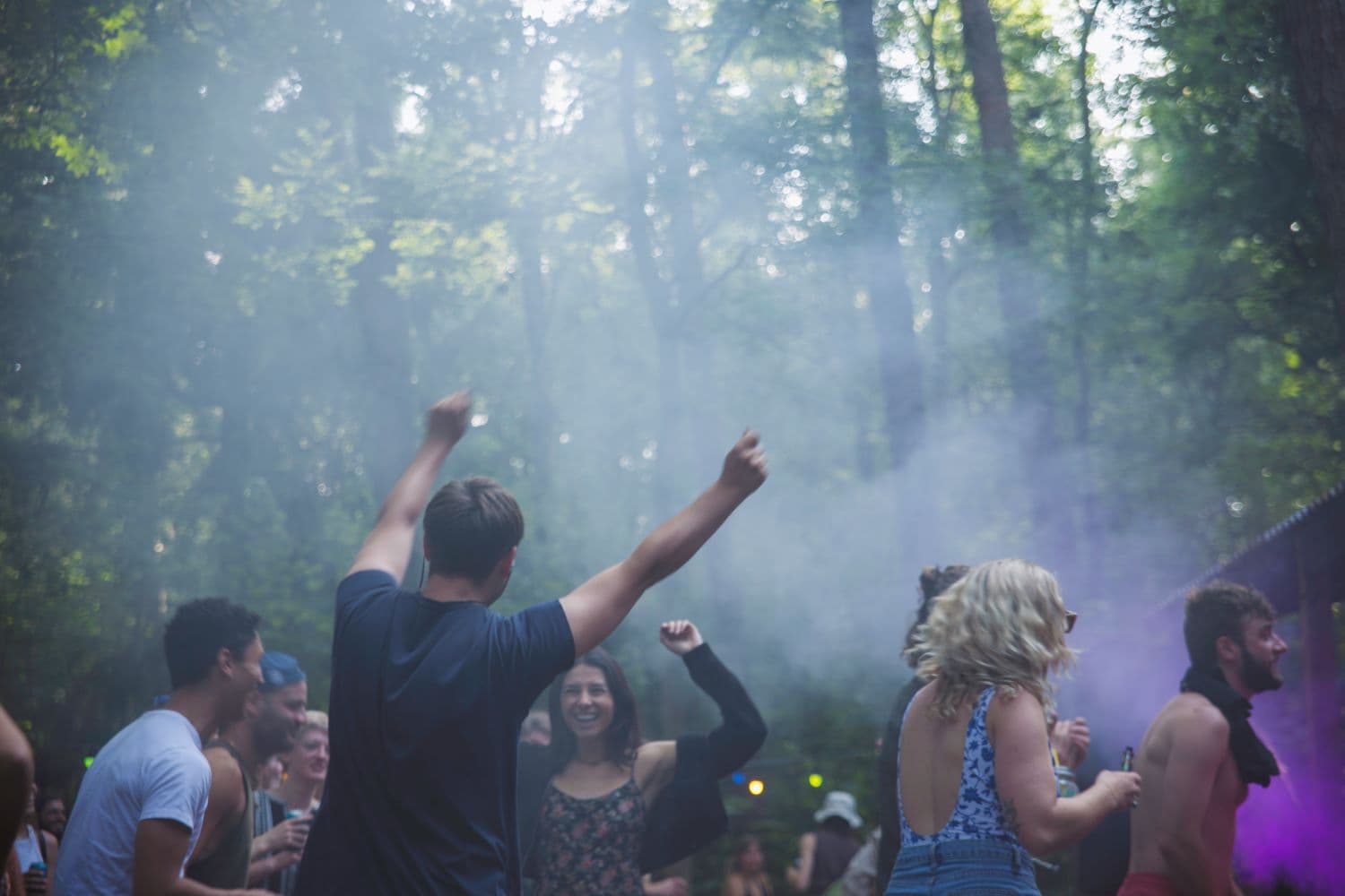 People dancing and smiling in the woods