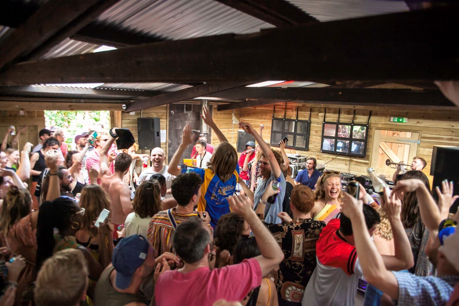 Crowd of people singing along to a band in a barn